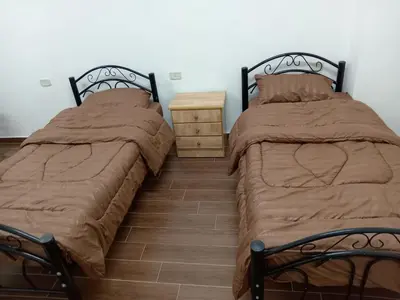two beds sitting next to each other in a bedroom at EMILE ALTWAL Hotel in Madaba