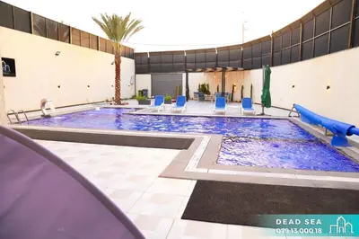 a large swimming pool with blue chairs in a building at PYRAMID Chalets - شاليهات الهرم in Al Baḩḩāth