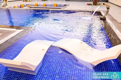 a swimming pool with a white seat in the water at PYRAMID Chalets - شاليهات الهرم in Al Baḩḩāth