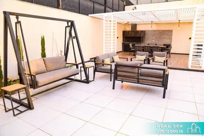 a patio with chairs and a table and a kitchen at PYRAMID Chalets - شاليهات الهرم in Al Baḩḩāth