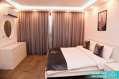 a bedroom with a bed and a large window at PYRAMID Chalets - شاليهات الهرم in Al Baḩḩāth