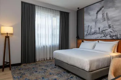 a hotel room with a bed and a large window at Radisson Blu Hotel, Amman Galleria Mall in Amman
