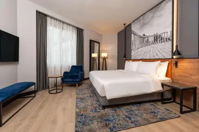a hotel room with a bed and a blue chair at Radisson Blu Hotel, Amman Galleria Mall in Amman