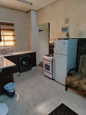 a kitchen with a stove and a white refrigerator at شقة ام نوارة الحديثة modern nice flat in Amman