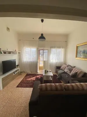 a living room with a couch and a tv at Homey Apt. with beautiful view in Amman