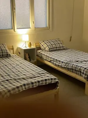 a room with two beds and a lamp on a table at Homey Apt. with beautiful view in Amman
