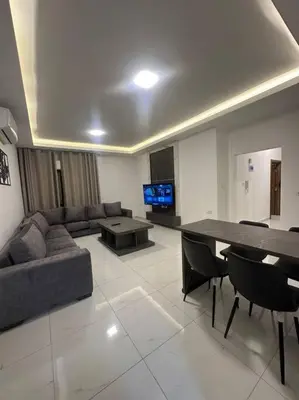 a living room with a couch and a table at cozy home near all services 20 in Rujm ash Sharāʼirah