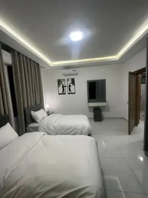 a hotel room with two beds and a television at cozy home near all services 20 in Rujm ash Sharāʼirah