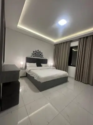 a bedroom with a large bed and a window at cozy home near all services 20 in Rujm ash Sharāʼirah
