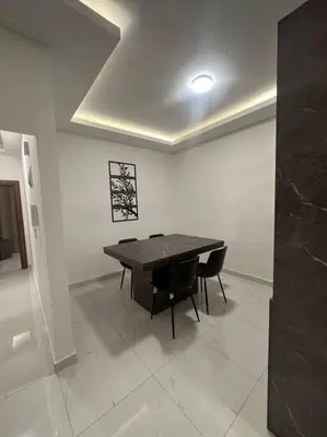 a dining room with a table and two chairs at cozy home near all services (19) in Rujm ash Sharāʼirah