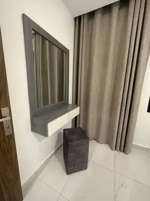 a bathroom with a flat screen tv and a stool at cozy home near all services (19) in Rujm ash Sharāʼirah
