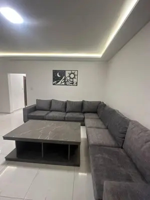 a living room with a couch and a coffee table at cozy home near all services (22) in Rujm ash Sharāʼirah
