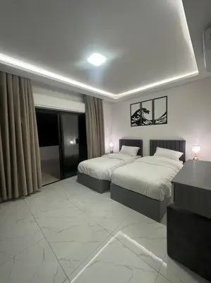 a hotel room with two beds and a table at cozy rooftop near al services 23 in Rujm ash Sharāʼirah