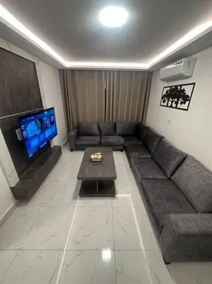 a living room with a couch and a tv at cozy rooftop near al services 23 in Rujm ash Sharāʼirah