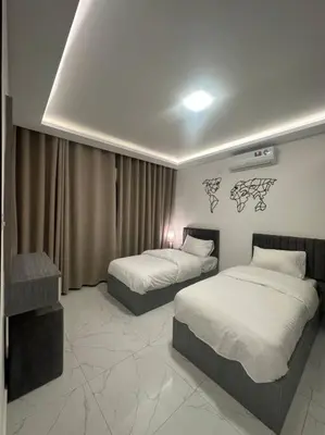 a hotel room with two beds in a bedroom at cozy rooftop near al services 24 in Rujm ash Sharāʼirah