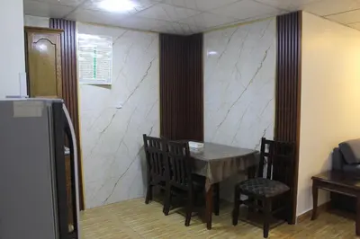 a dining room with a table and chairs in a room at الأحفاد للشقق الفندقية Al Ahfad Hotel Apartments in Şāfūţ