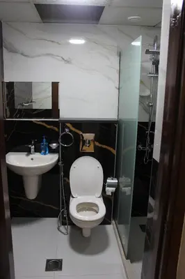 a bathroom with a toilet and a sink at الأحفاد للشقق الفندقية Al Ahfad Hotel Apartments in Şāfūţ