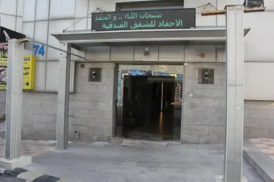 an entrance to a building with a sign on it at الأحفاد للشقق الفندقية Al Ahfad Hotel Apartments in Şāfūţ