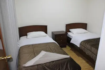 two beds sitting next to each other in a room at الأحفاد للشقق الفندقية Al Ahfad Hotel Apartments in Şāfūţ