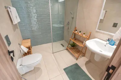 a bathroom with a shower and a toilet and a sink at Nammos Experience in Amman