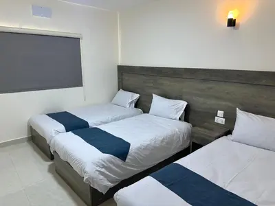a bedroom with two beds and a large window at Happy Beach Castel for Apartment قلعة شاطئ السعادة للشقق المفروشة in Aqaba