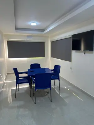 a meeting room with a table and blue chairs at Happy Beach Castel for Apartment قلعة شاطئ السعادة للشقق المفروشة in Aqaba