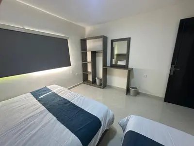 a bedroom with two beds and a large window at Happy Beach Castel for Apartment قلعة شاطئ السعادة للشقق المفروشة in Aqaba