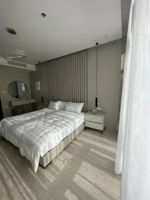 a bedroom with a large bed and a television at Abdoun luxurious apartment in Amman