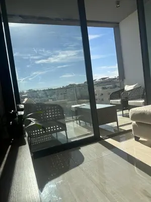 a room with a large window with a table and chairs at Abdoun luxurious apartment in Amman