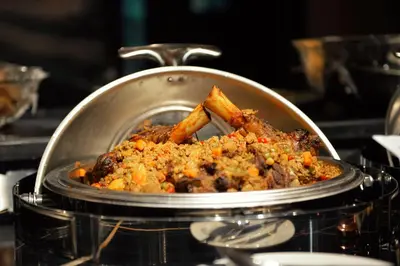 a pan filled with food in a stove at Petra Bermudez Hotel in Wadi Musa