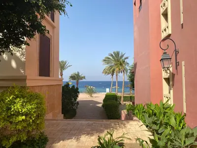 a walkway between two buildings with the ocean in the background at Talabay Top cosy 3 bedroom apartment in Aqaba