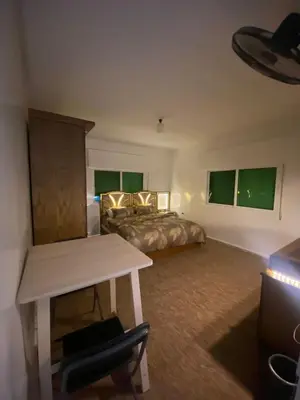 a bedroom with a bed and a desk and a table at شقه مفروشه مميزه in Irbid
