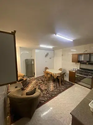 a living room with a table and a kitchen at شقه مفروشه مميزه in Irbid