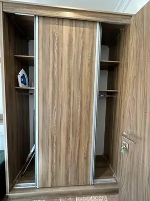 a wooden closet with glass doors in a room at 1/ Antica jabalal-lwebdeh in Amman