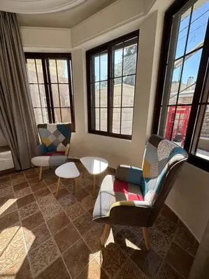 a living room with chairs and a table and windows at 1/ Antica jabalal-lwebdeh in Amman