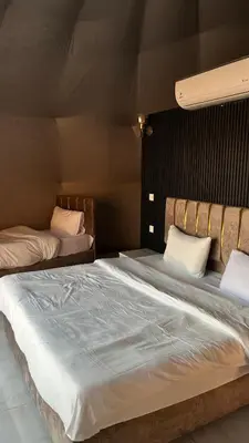 a large bed with white sheets in a bedroom at Madonna Rum camp bubbles & Jeep tours in Wadi Rum