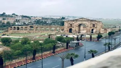 a view of a building with palm trees and a street at white tulips studio in Jerash