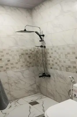 a bathroom with a shower with a sink and a toilet at white tulips studio in Jerash
