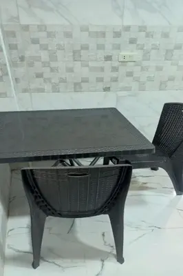 a black table and a chair in a room at white tulips studio in Jerash