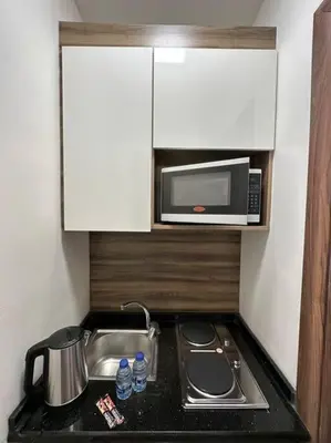 a small kitchen with a sink and a microwave at 2/ Antica jabalal-lwebdeh in Amman