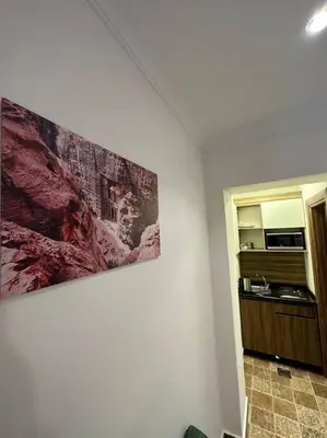 a room with a painting on the wall and a kitchen at 2/ Antica jabalal-lwebdeh in Amman