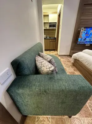 a green couch with two pillows on it in a room at 2/ Antica jabalal-lwebdeh in Amman