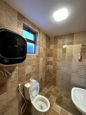 a bathroom with a toilet and a television on the wall at 2/ Antica jabalal-lwebdeh in Amman