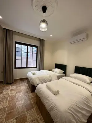 a hotel room with three beds and a window at 3/ Antica jabalal-lwebdeh in Amman
