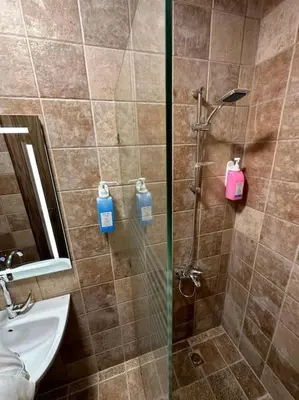 a shower with a glass door next to a sink at 4/ Antica jabalal-lwebdeh in Amman