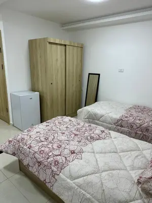 a bedroom with two beds with pink and white blankets at Karak Plaza Residences in Kerak