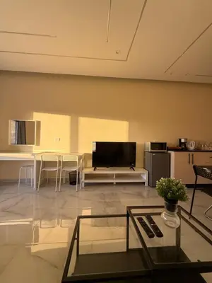 a living room with a tv and a couch and a table at Karak Plaza Residences in Kerak