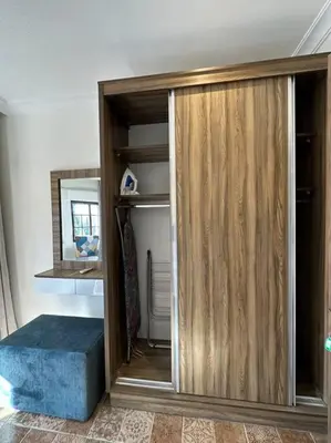 a room with a wooden closet with a blue ottoman at 6/ Antica jabalal-lwebdeh in Amman