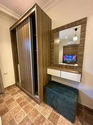 a bathroom with a television and a blue ottoman at 6/ Antica jabalal-lwebdeh in Amman