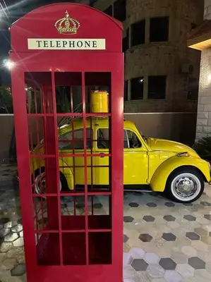 a red phone booth in front of a yellow car at 6/ Antica jabalal-lwebdeh in Amman